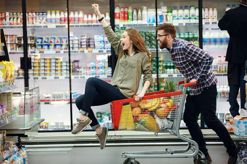 Mann und Mädchen im Supermarkt haben Spaß
